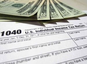 Twenty Dollar Bills on top of a 1040 Tax Return